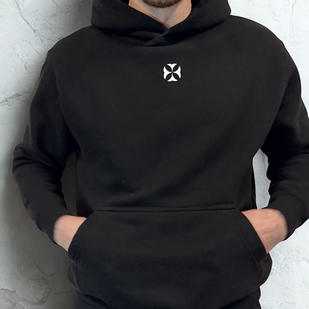 Person wearing a black hoodie with a white logo on a light gray background
