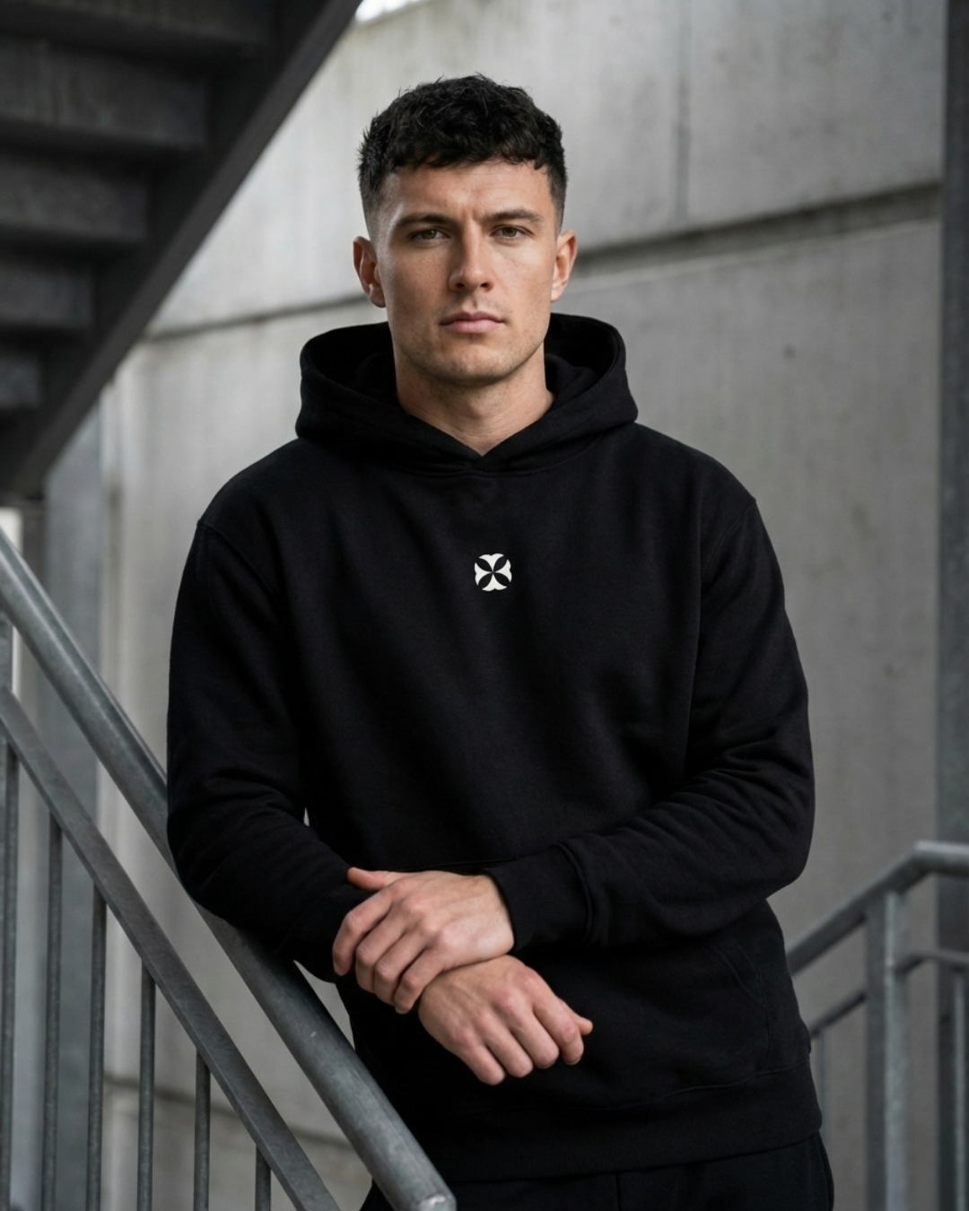 A man leans against a rail in a black LCKY INC Hoodie