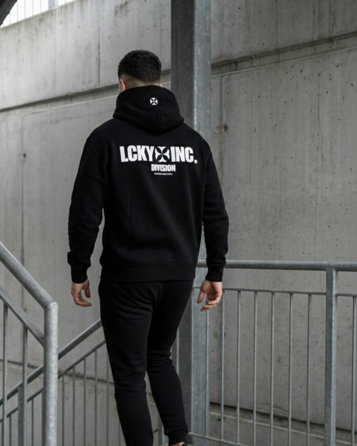 A man in a black LCKY INC hoodie walks downstairs